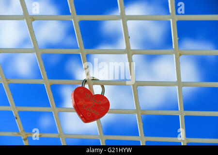 Cadenas rouge en forme de coeur, amour, verrou sur grille dans frint de ciel bleu, Basse-Saxe, Allemagne Banque D'Images