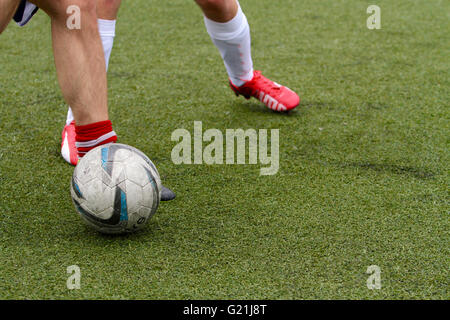 Les jambes de 2 joueurs jouant au football (soccer) avec un joueur possédant la balle