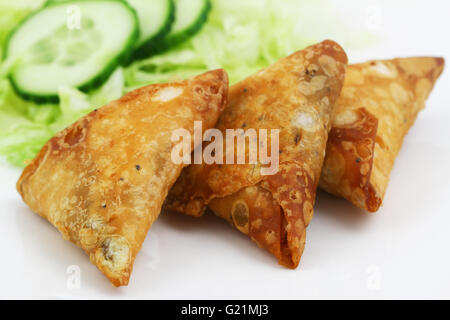 Samosas Indiens trois vert avec de la laitue et des tranches de concombre sur le côté, gros plan Banque D'Images