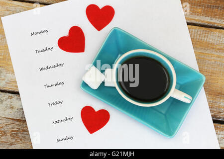 En semaine écrit le morceau de papier blanc avec une tasse de café avec trois coeurs rouges Banque D'Images