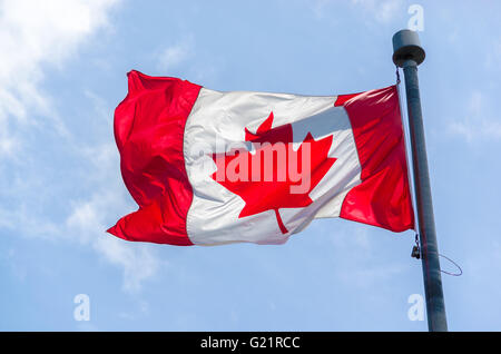 Drapeau canadien dans le vent plus de ciel bleu avec des nuages Banque D'Images