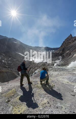 Cratère du volcan actif sur le Kamchatka : les touristes sur fond de paysage volcanique avec fumerolles actives, de l'éjection de gaz et vapeur. Banque D'Images