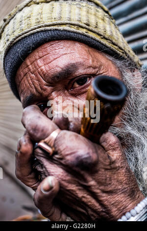 Homme fumant une pipe à Delhi, Inde Banque D'Images