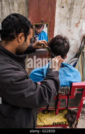 Salon de coiffure en plein air une coupe de cheveux des clients à Delhi, Inde Banque D'Images