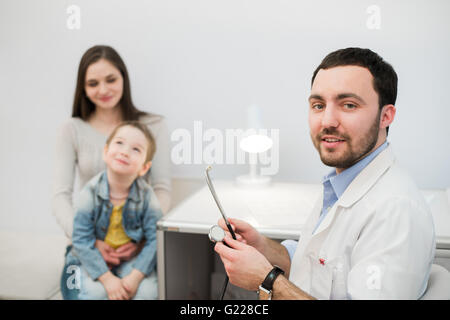 Doctor examining petite fille avec sa mère in medical office Banque D'Images