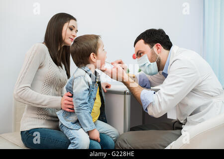 Petit garçon ayant sa gorge examiné par un professionnel de la santé Banque D'Images