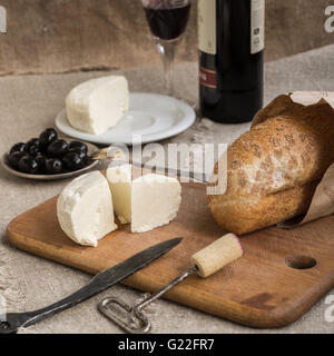 Verre, bouteille de vin, pain et fromage sont la mise à Banque D'Images