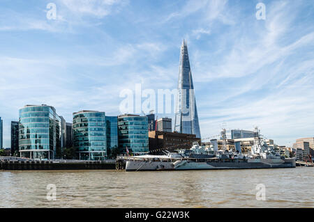 Au bord de l'HMS Belfast Londres avec navire et les édifices à bureaux d'une journée ensoleillée avec ciel bleu Banque D'Images