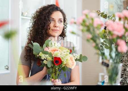 Portrait de belle jeune femme debout dans le magasin de fleurs fleuriste Banque D'Images