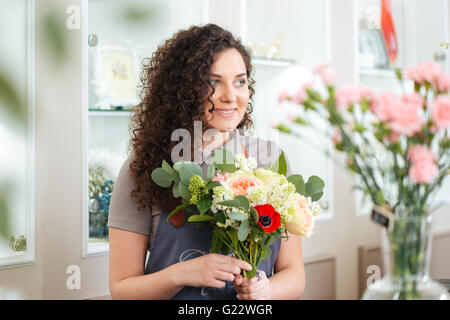 Happy cute jeune femme travaillant dans le magasin de fleurs fleuriste Banque D'Images