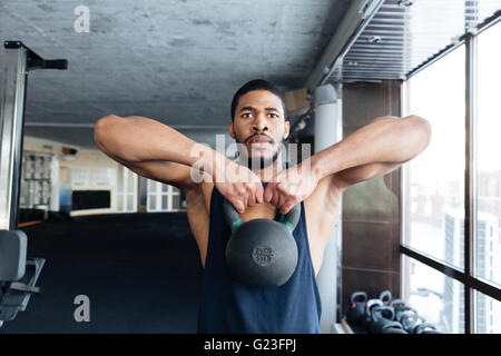 Remise en forme santé guy faisant entraînement avec l'aide de lourdes kettlebell dans la salle de sport Banque D'Images