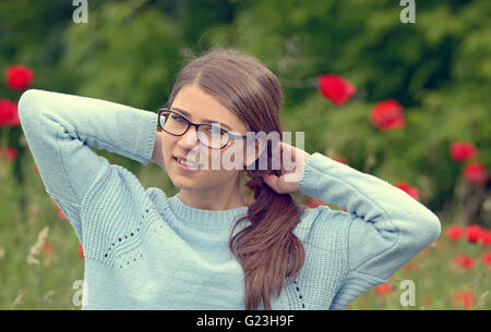 Portrait de jeune fille dans un champ de coquelicots Banque D'Images