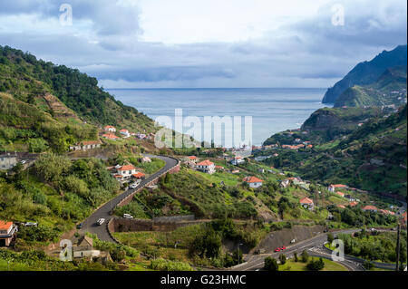 Paysage typique de l'île de Madère, la serpentine route de montagne, des maisons sur les collines et sur l'océan Banque D'Images