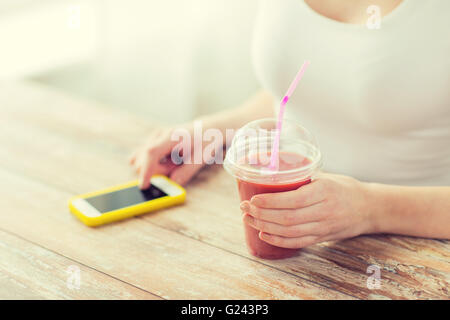 Close up of woman with smartphone smoothie et Banque D'Images