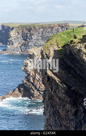 Walker au bord de la falaise sur la section de la côte de Loop Head, Comté de Clare, Irlande Banque D'Images