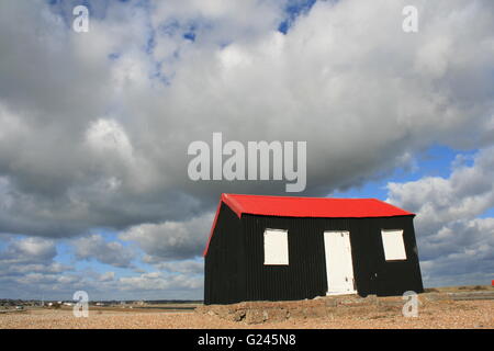 Un PAYSAGE À RYE HARBOUR NATURE RESERVE D'UN FISHEMANS AU TOIT ROUGE HUT PAR LA RIVIÈRE AU SOLEIL AVEC NUAGE intéressant Banque D'Images