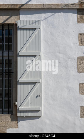 Panneau de fenêtre en bois gris sur un mur blanc. Banque D'Images