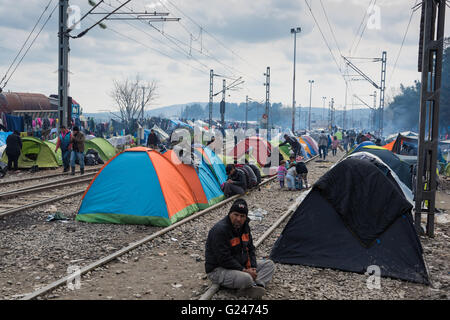 Les réfugiés en provenance de Syrie s'asseoir près de leurs tentes le 17 mars 2015 dans le camp de réfugiés de Idomeni, Grèce. Banque D'Images