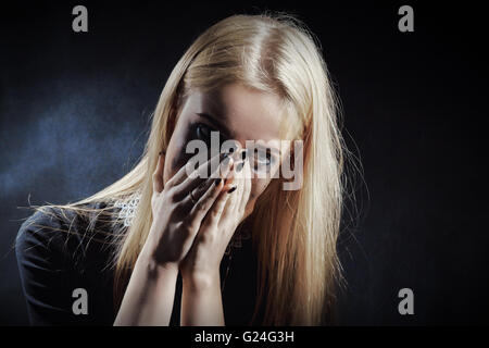 Triste choqué girl crying sur fond noir Banque D'Images