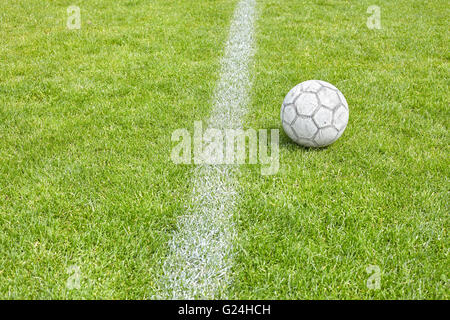 Ballon de soccer utilisé sur l'herbe par un à-côté, de l'espace pour texte, faible profondeur de champ. Banque D'Images