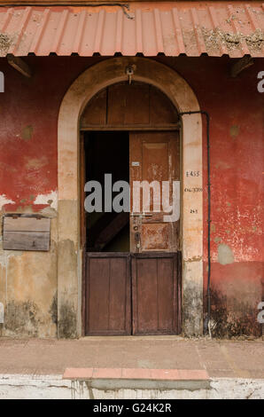 Détails d'une porte en bois voûté d'un rouge brique maison portugaise à Fontainhas, Panaji (Panjim), Goa, Inde Banque D'Images