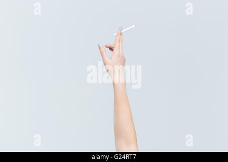 Closeup portrait of female hand holding cigarette isolé sur fond blanc Banque D'Images