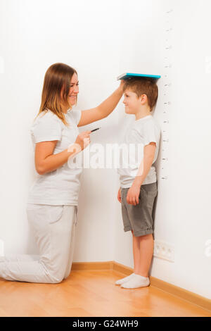 Son fils mère contrôle de hauteur sur la courbe de croissance Banque D'Images