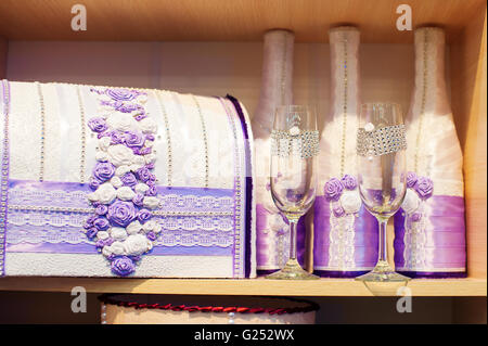 Verres de champagne et une boîte pour de l'argent sur des tons violets en mariage Banque D'Images