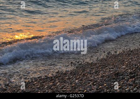 Les vagues du soir sur la plage avec la mer scintillante. Sukosan, Croatie Banque D'Images