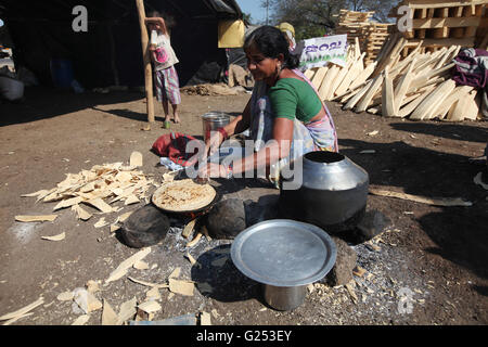 Woman making Rotis / Blé Roti assis sur le côté de la route dans le Village, district Nanded Kamathi, Maharashtra, Inde Banque D'Images