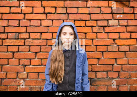 Cute Smiling woman standing contre mur de brique rouge Banque D'Images