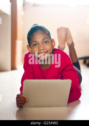 Chambre Girl lying on floor with digital tablet Banque D'Images