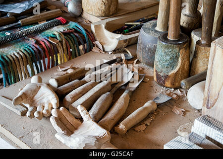 Mains en bois sculpté et de ciseaux et outils de travail du bois dans un atelier de sculptures en bois. UK Banque D'Images