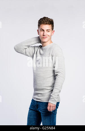 Garçon en jeans et chandail, jeune homme, studio shot Banque D'Images