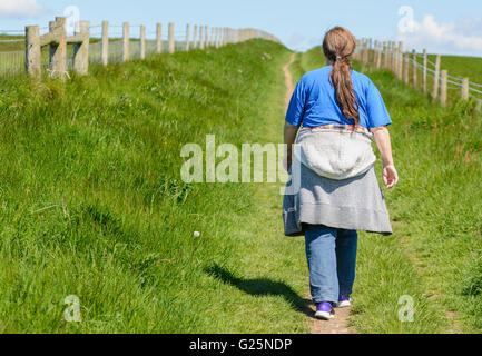 La perte de poids. Woman walking away le long chemin d'un pays. Le mode de vie sain. Mode de vie sain. Obtention d'ajusteur. Garder l'ajustement. Banque D'Images