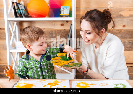 Jeune mère joyeuse et son petit fils s'amusant et de peinture sur les mains Banque D'Images