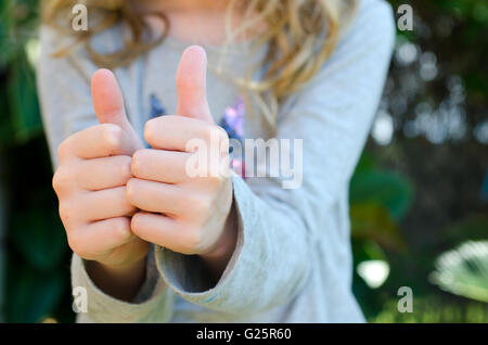 Close up de l'enfant qui a deux pouces vers le haut Banque D'Images