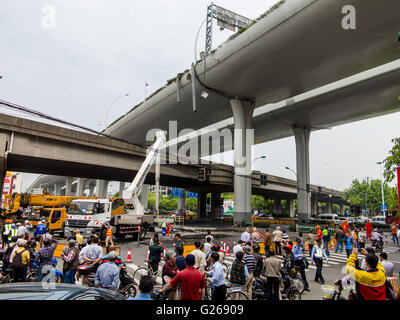 Shanghai, Shanghai, CHN. 25 mai, 2016. Shanghai, Chine - le 23 mai 2016 : (usage éditorial uniquement. Chine OUT) Un camion surchargé illégales comportant 10 mètres de long tuyau de ciment a traversé le viaduc à Shanghai, et a eu un accident de voiture entre Zhenhua Road et de Wanrong Road à 0:30 Mai 23. La surface du pont est lourdement endommagé. Les travailleurs viennent de le réparer à l'aide d'une grue dans la matinée. © SIPA Asie/ZUMA/Alamy Fil Live News Banque D'Images