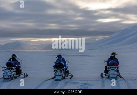 Motoneiges avec montagnes enneigées Longyearbyen au crépuscule, Svalbard, Spitzberg, Norvège Banque D'Images