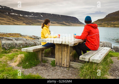 Un couple de boire du thé à proximité d'un magnifique lac Banque D'Images