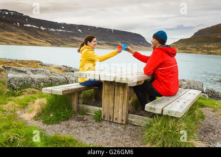 Un couple de boire du thé à proximité d'un magnifique lac Banque D'Images