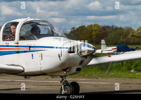 Un Piper PA-38, G-BRHR taxis à après l'atterrissage à l'aérodrome d'Elstree en Hertfordshire, Royaume-Uni. Close-up de cockpit, moteur et hélice Banque D'Images