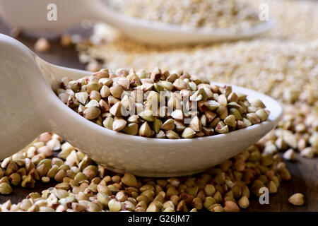 Libre de quelques cuillères en céramique avec différentes graines comestibles comme le sarrasin ou quinoa, sur une surface en bois rustique Banque D'Images