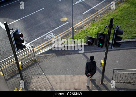 Asian man walking aux feux de circulation (vue de dessus, Glasgow, Ecosse, Royaume-Uni. Banque D'Images