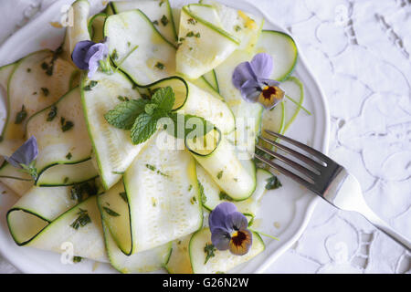 Fleurs comestibles et la courgette courgette salade avec vinaigrette citron menthe, selective focus Banque D'Images