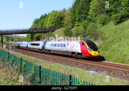 Pendolino Virgin train électrique de l'inclinaison qu'il arrondit une courbe sur la West Coast Main Line près de Beckfoot dans Cumbria Banque D'Images