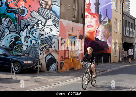 Des cyclistes et des graffitis, dont Aung San Suu Kyi, Kensington Street, North Laine, Brighton, East Sussex, Angleterre Banque D'Images