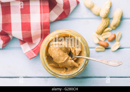 Le beurre d'arachide crémeux et les arachides. Tartiner de beurre d'arachides dans le jar. Banque D'Images