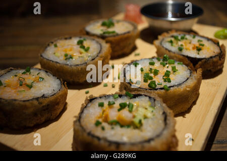 Sushi frits délicieusement servi avec sauce chili, wasabi et gingembre mariné. Banque D'Images