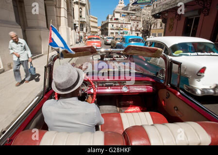 Un chauffeur de taxi au volant de sa1955 Pontiac Star Chief convertible dans la vieille ville de La Havane, Cuba. Banque D'Images